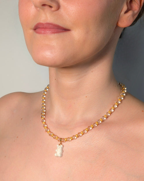 White gummy bear charm beaded necklace with clear crystal and gold seed beads, worn on neck - handmade playful jewelry by Pretty Match Amsterdam